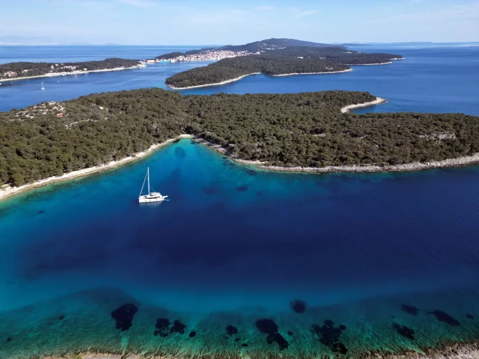 Sailing yacht anchored in a forested Dalmatian bay